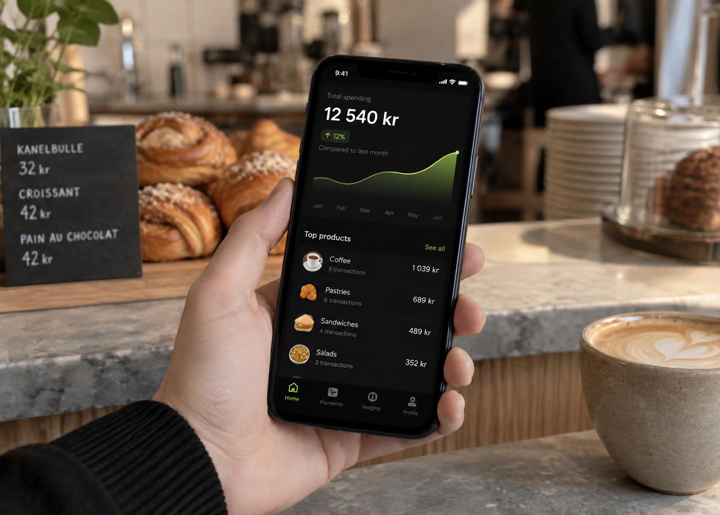 Phone in a café showing a Kai monthly report with revenue and margin